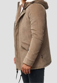 Braune Cordjacke mit Kapuze, ausgestattet mit einem weichen Fleece-Futter, Reißverschluss und zwei Vordertaschen mit Druckknöpfen.