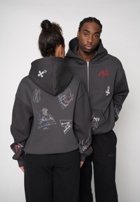 Grauer Kapuzenpullover mit Reißverschluss und verschiedenen bunten Grafiken auf Rücken und Ärmeln. Hergestellt aus weichem Stoff mit lockerem Sitz.