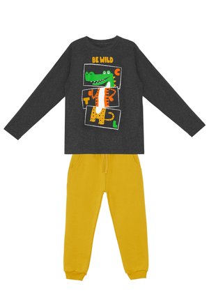 Dunkelgraues Langarmshirt mit "Be Wild" und buntem Cartoon-Krokodil-Design, kombiniert mit hellgelben Jogginghosen mit Taschen.