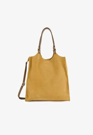 Leather tote bag in mustard yellow with a smooth texture, featuring dual handles and an adjustable shoulder strap. Minimalist design, no visible hardware.