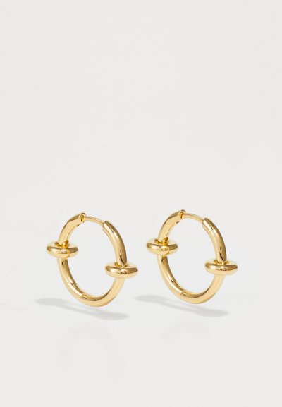 Gold hoop earrings feature a smooth, rounded design with two central accents, polished finish, and a secure clasp for easy wear.