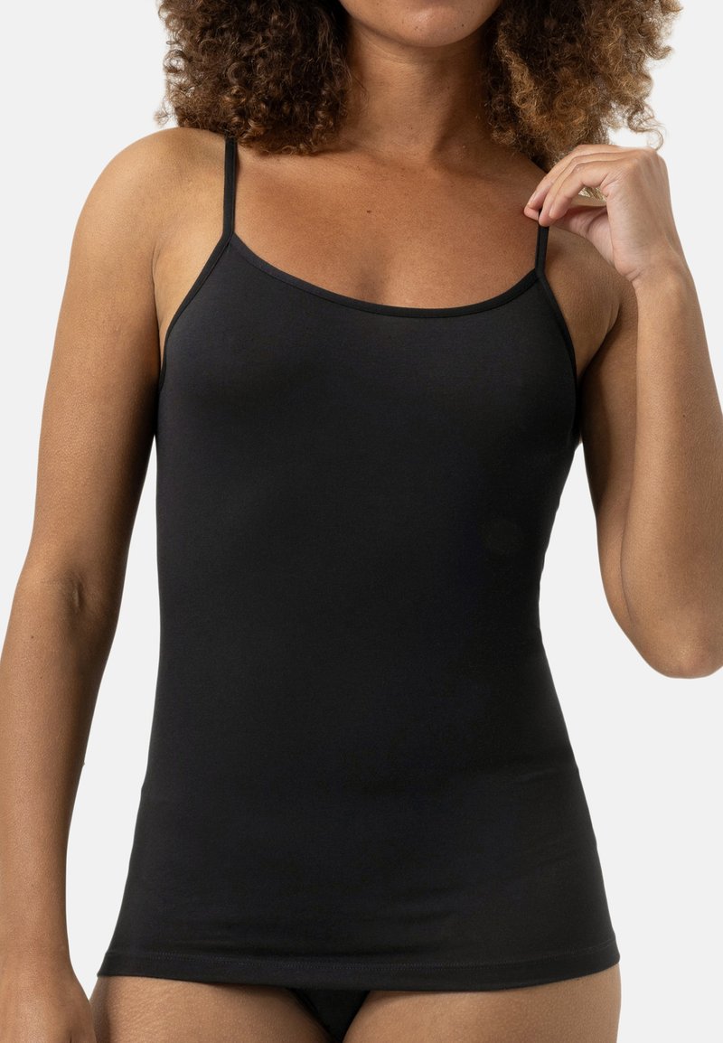 Camisola nera realizzata in un tessuto morbido ed elastico. Presenta spalline sottili regolabili e un design aderente, con una texture liscia e dettagli minimi.