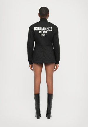 Mustat tikatut takki korkealla kauluksella ja pitkillä hihoilla, jossa on valkoinen "DSQUARED2 MILANO 1995" -teksti selässä.