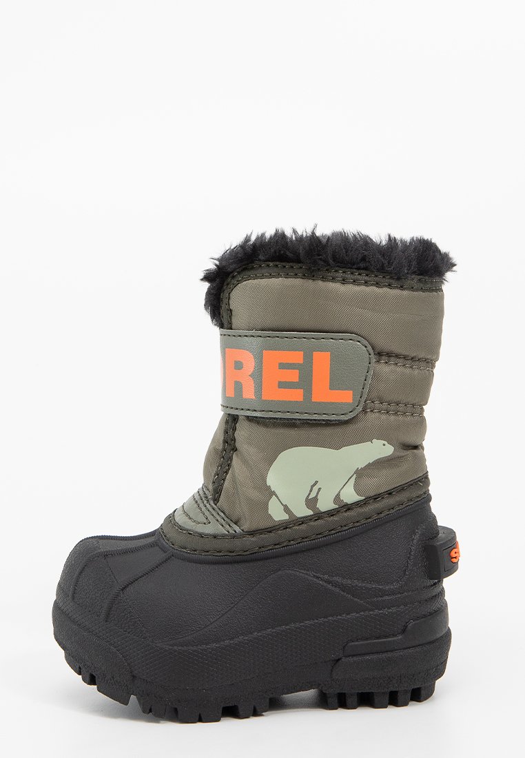 Grüner Winterstiefel aus Stoff mit schwarzer Gummisohle, ausgestattet mit einem flauschigen Schaft, orangefarbenem "SOREL"-Logo und grafischem Detail eines Eisbären.
