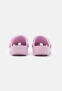 Pink rubber clogs with open back, side ventilation holes, and textured sole for grip. Smooth material and rounded shape.