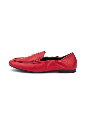 Scarpa slip-on in pelle rossa con dettagli cuciti, punta arrotondata, profilo basso, texture morbida e suola in gomma flessibile.