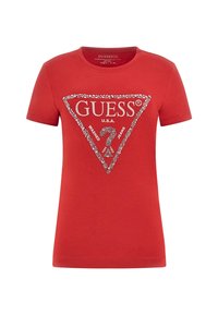 Červené bavlněné tričko s kulatým výstřihem a krátkými rukávy, které má trojúhelníkový design loga posetý rhinestony s nápisem "GUESS U.S.A.".