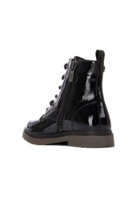 Botines de charol negro con cremallera lateral, parte delantera con cordones y una suela de goma resistente con un borde texturizado en contraste.