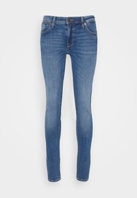 Világoskék, slim fit fazonú farmernadrág, klasszikus öt zsebes kialakítással, gombbal záródik és minimális kopási részletekkel rendelkezik.