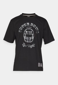 Maglietta nera con un design grafico che presenta "SUPER BOWL LVIII", un casco da football e il testo "Las Vegas", marchiata con "BOSS."