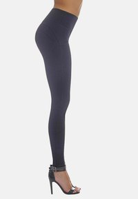 Czarne legginsy z wysokim pasem, gładką teksturą oraz szwami podkreślającymi sylwetkę; noszone z czarnymi szpilkami na wysokim obcasie z paskami wokół kostki.