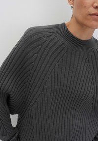 Maglione grigio a coste con motivi verticali e diagonali testurizzati, colletto rotondo e maniche ampie.