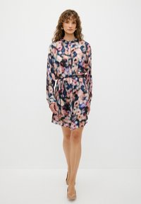 Blommönstrad klänning i mjukt tyg, med knäppning framtill, långa ärmar, ett bälte i midjan och en något utsvängd kjol. Färgerna inkluderar rosa, blå och krämfärgad.