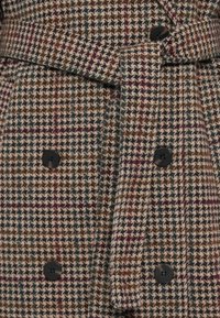 Vilnos mišinio paltas su šuns danties raštu, juodais mygtukais, diržu ir rudos, žalios bei bordo spalvų deriniu.