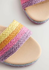 Woven nazouváky s pastelovými pruhy v odstínech žluté, oranžové, růžové a fialové. Měkká béžová stélka s texturovaným povrchem a světlemodrým akcentem.