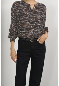 Blusa a maniche lunghe in tessuto scuro con un motivo a righe bianche e arancioni bruciati, caratterizzata da un'apertura frontale con bottoni e una vestibilità comoda.