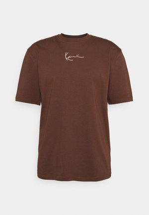 Brązowy T-shirt z krótkim rękawem i okrągłym dekoltem z białym kursywnym napisem umieszczonym centralnie blisko kołnierza, który brzmi "KARL."