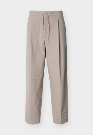 Pantaloni beige con coulisse in tessuto strutturato, gambe dritte e vita elastica, mostrati su sfondo bianco.