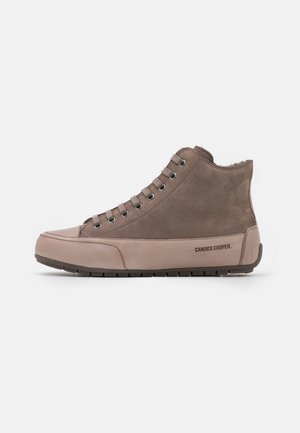 High-top sneakers made of brown leather, featuring silver eyelets, a smooth sole, and a subtle logo on the side. Soft interior lining visible.