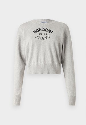 Gaiši pelēks īss džemperis, kas izgatavots no mīksta auduma. Iespējas ietver apaļu kakla izgriezumu, garas piedurknes un melnu izšūtu tekstu: "MOSCHINO 86-23 JEANS."