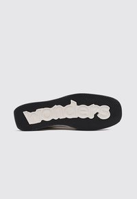 Suela de goma negra con superficie texturizada, que cuenta con un prominente logo blanco de "wonders". Diseño elegante y plano con bordes redondeados.