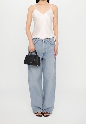 Hvid satin cami-top, lysvaskede vide jeans, sort håndtaske med top-håndtag og sorte sandaler med stropper. Enkel og minimalistisk design.