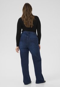 Mørkeblå jeans med høj talje og lige ben, med to baglommer og en blød denimtekstur. Afsmalnende kant med minimal syning.