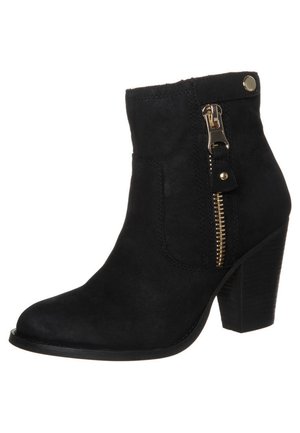 Schwarzer Wildleder-Stiefelette mit Blockabsatz, seitlichem goldfarbenem Reißverschluss und kleinem Metallknopf am oberen Bund.