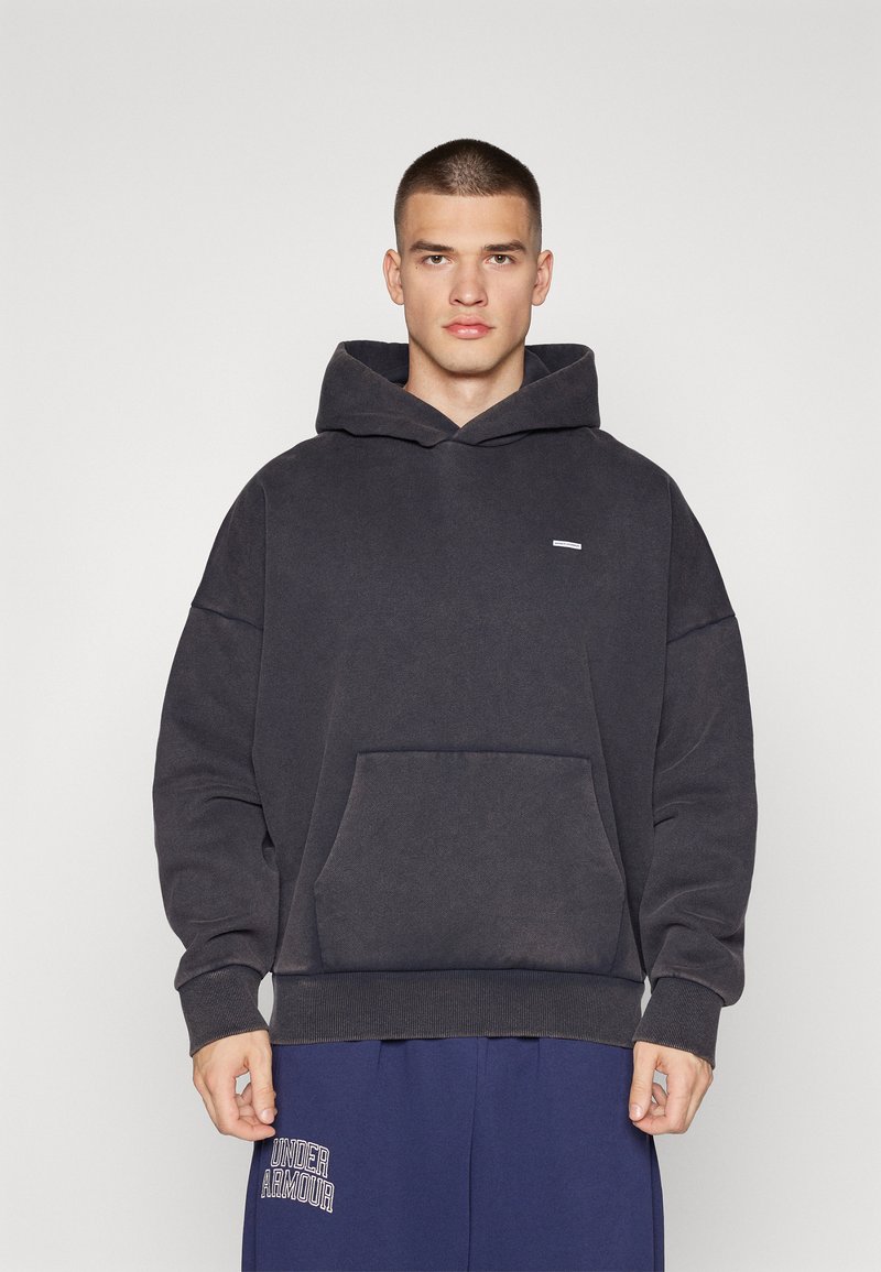 Σκούρο γκρι υπερμεγέθη φούτερ με μπροστινή τσέπη, διαθέτει κουκούλα με κορδόνι και μικρό λογότυπο στο στήθος. Μαλακό, υφασμάτινο υλικό.