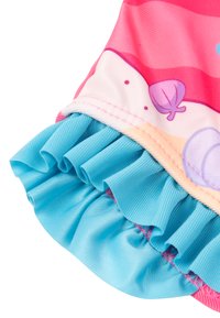 Colorful swimwear featuring a pink and white top with aquatic designs and a blue ruffled hem. Smooth fabric with a slight sheen.