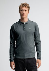 Dunkelgraues Langarm-Polohemd mit Kragen, drei schwarzen Knöpfen und einem kleinen Logopatch auf der Brust. Weiches, strukturiertes Material.