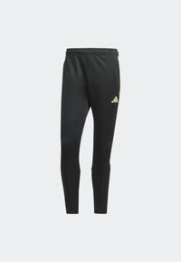 Černé sportovní kalhoty s úzkým střihem, vyrobené z elastické tkaniny. Mají žluté logo Adidas a boční proužky jako detail. Elastický pas.