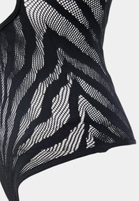 Svart bodysuit med ett mönster av texturerad zebra-mesh, med solida tygdetaljer längs kanterna.