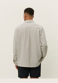 Lange mouwen geruite shirt in licht beige met bruine en teal ruitpatronen, voorzien van een button-down kraag en een details op de rug.