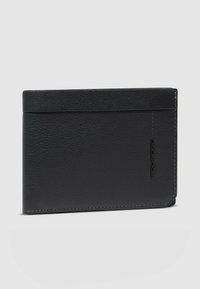 Cartera de cuero negro con acabado texturizado, forma rectangular y costuras en contraste. Presenta un logotipo en el lateral.