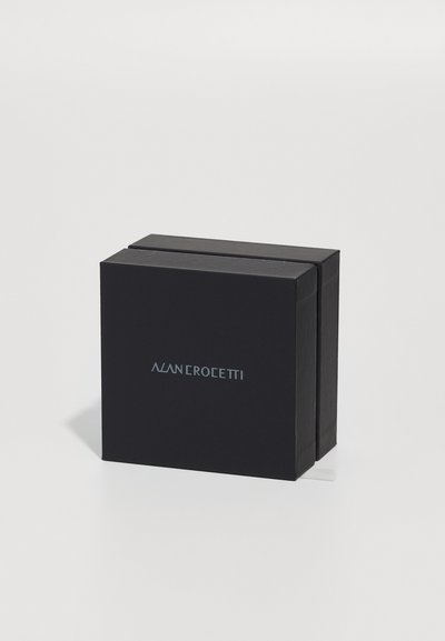 Cutie neagră rectangulară cu un exterior neted, având un logo subtil embosat. Designul include o închidere simplă în partea de sus.