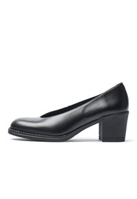 Zapato negro de piel con punta redondeada y tacón bajo en bloque. Presenta una textura suave y un sutil pespunte a lo largo de la suela.
