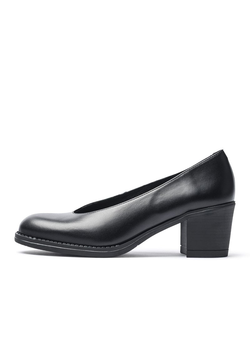 Zapato negro de piel con punta redondeada y tacón bajo en bloque. Presenta una textura suave y un sutil pespunte a lo largo de la suela.