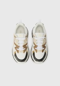 Adidași albi cu un material texturat, accente metalice aurii și negre, vârf rotund, talpă cusută neagră și șireturi albe.