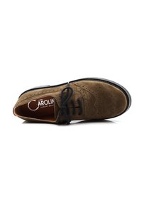 Zapato oxford de ante marrón con detalles perforados, cordones negros y suela negra. En el interior, presenta una plantilla contrastante en color naranja.