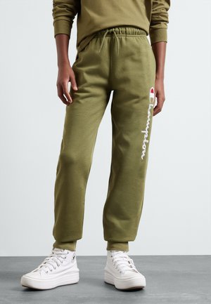 Pantalons de jogging vert olive avec une taille élastique, comportant un logo "Champion" brodé en blanc sur la jambe gauche et une coupe décontractée.