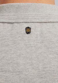 Sudadera de punto gris con cuello acanalado. Cuenta con una etiqueta negra y dorada "PME LEGEND" cosida en la parte posterior del cuello. Textura suave, diseño casual.