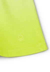 Shorts atletici giallo brillante realizzati in tessuto a coste. Presentano un logo ricamato all'orlo e cuciture rinforzate lungo i bordi.