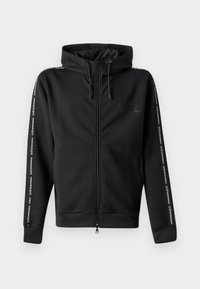 Sudadera negra con cremallera y capucha ajustable, que presenta un logo en el pecho y cinta estampada a lo largo de las mangas. Está fabricada con un tejido suave y tiene un corte relajado.
