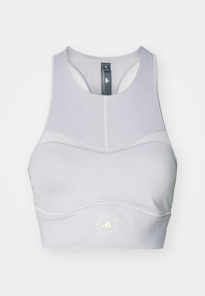 Light gray sports bra with a round neckline, racerback design, and reflective logo accent near the bottom. Made from stretchable fabric.