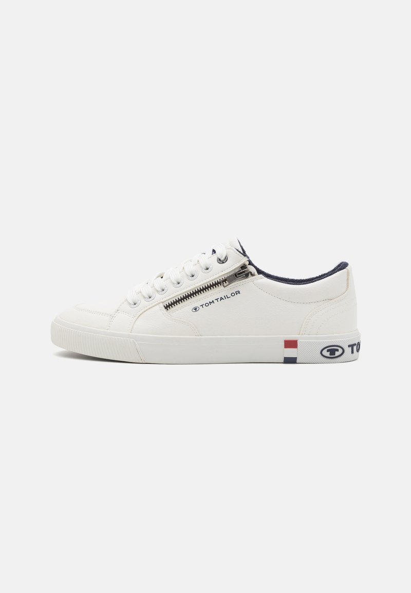 Witte sneaker met een leren bovenwerk, ronde neus en contrasterende marineblauwe details op de kraag. Beschikt over een ritsluiting en logo-accenten aan de zijkanten.