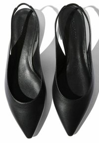 Ballerine slingback in pelle nera con punta affusolata e superficie liscia. Presentano un design minimalista, con una sottile fascia alla caviglia.