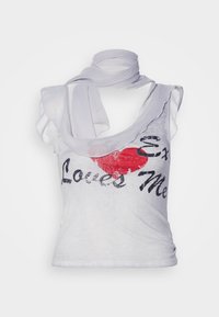 Chemise sans manches blanche avec une coupe ample, ornée d'un graphique de cœur rouge et d'un texte noir indiquant "Ex m'aime", complétée par une écharpe assortie.