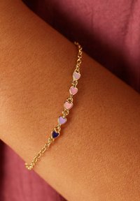 Gouden kettingarmband met afwisselende hartbedels in roze, lavendel en donkerblauw, die een gladde emaille afwerking en delicate schakels laat zien.