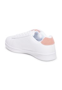 Zapatillas blancas con parte superior sintética lisa, cordones planos y un acento de gamuza rosa en el talón. Suela de goma plana para mayor tracción.